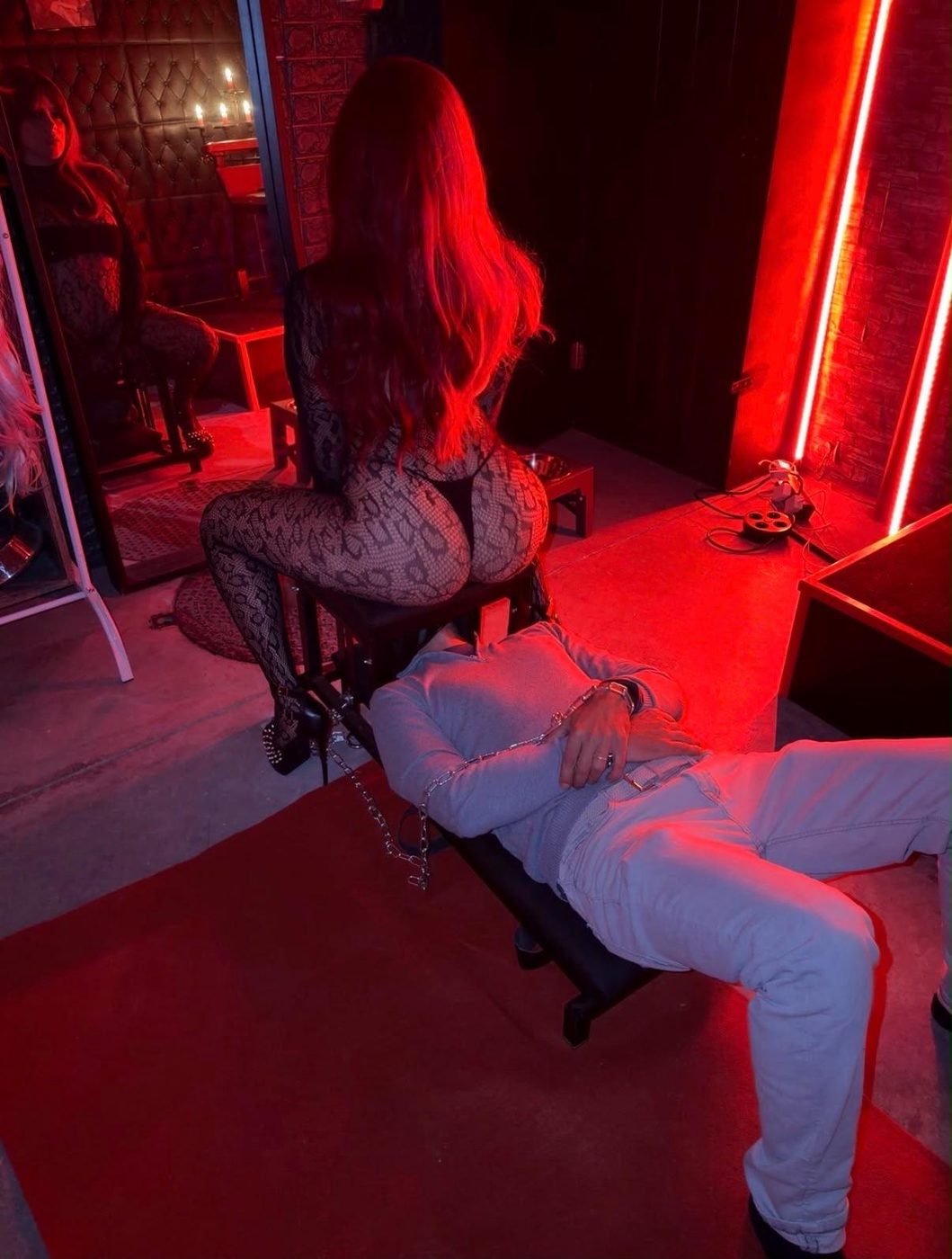 Divana sentada sobre su esclavo en la sala roja