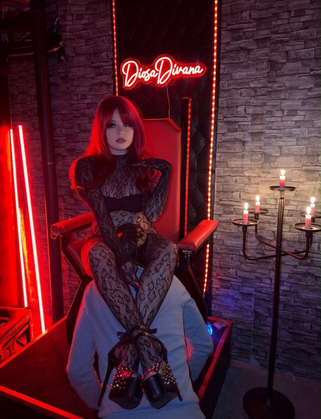Divana en su trono rojo, bajo el neón de su Palacio
